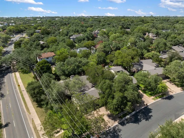 an aerial view of a house with a yard and lake