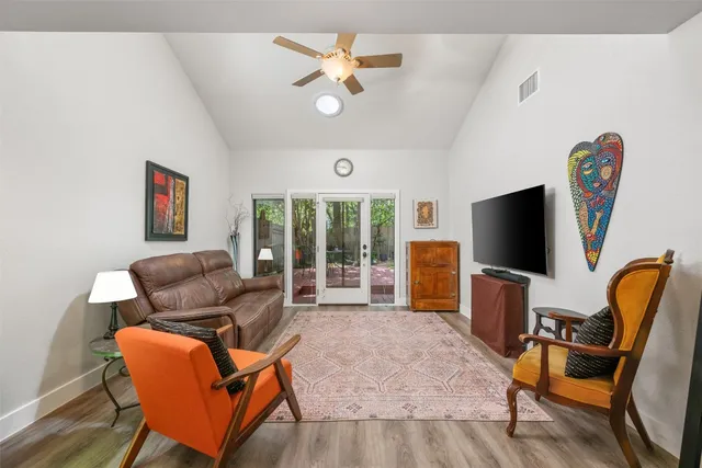 a living room with furniture a flat screen tv and a large window