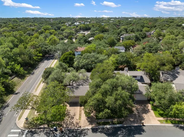 an aerial view of a house with a yard and lake view