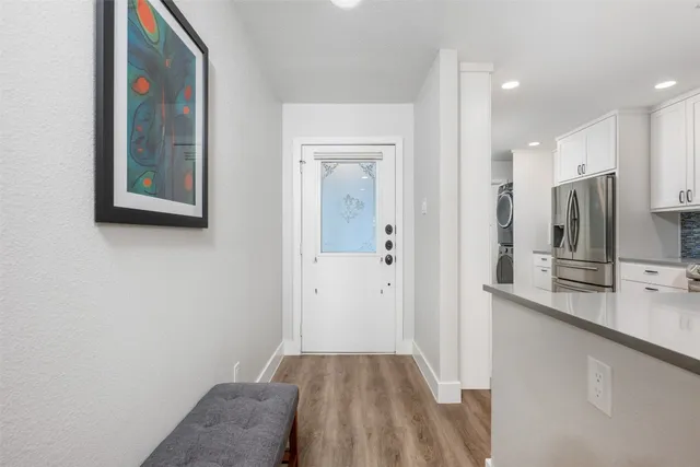 a view of hallway with kitchen island a sink a stove and a refrigerator