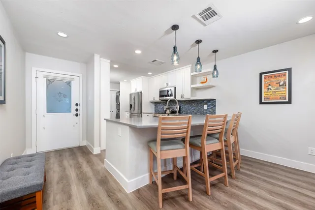 a kitchen with stainless steel appliances kitchen island granite countertop a dining table chairs and granite counter tops