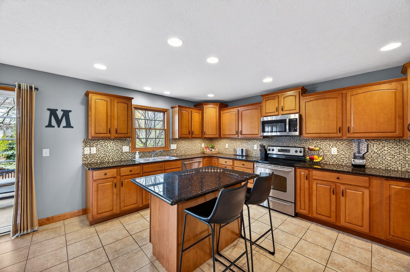 2968 Wolf Creek Lane Normal, IL 61761 - Photo 11 of 47 a kitchen with stainless steel appliances granite countertop wooden cabinets a sink a stove a dining table and chairs