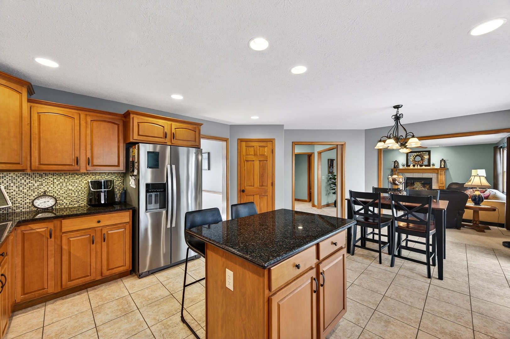 2968 Wolf Creek Lane Normal, IL 61761 - Photo 13 of 47 a kitchen with stainless steel appliances granite countertop a stove top oven a sink dishwasher a dining table and chairs with wooden floor