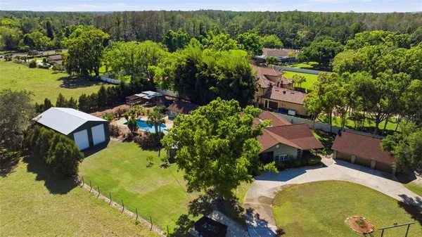 an aerial view of a house with swimming pool and garden
