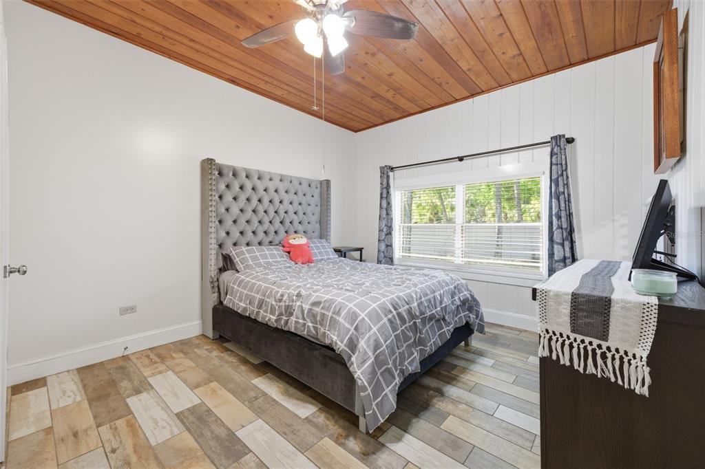 3752 Old Keystone Road Tarpon Springs, FL 34688 - Photo 26 of 71 a bedroom with a bed a flat screen tv and balcony