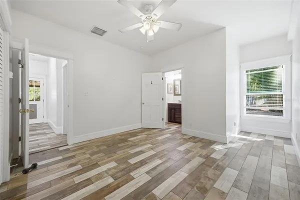 a view of a livingroom with a ceiling fan window and wooden floor