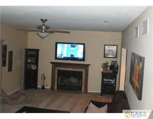 39 Haypress Road Dayton, NJ 08810 - Photo 4 of 11 a living room with furniture a fireplace and a flat screen tv