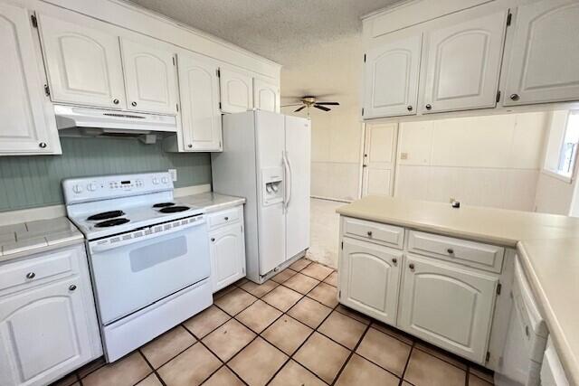 406 Spring Lane Destin, FL 32541 - Photo 13 of 25 a kitchen with white cabinets and white appliances
