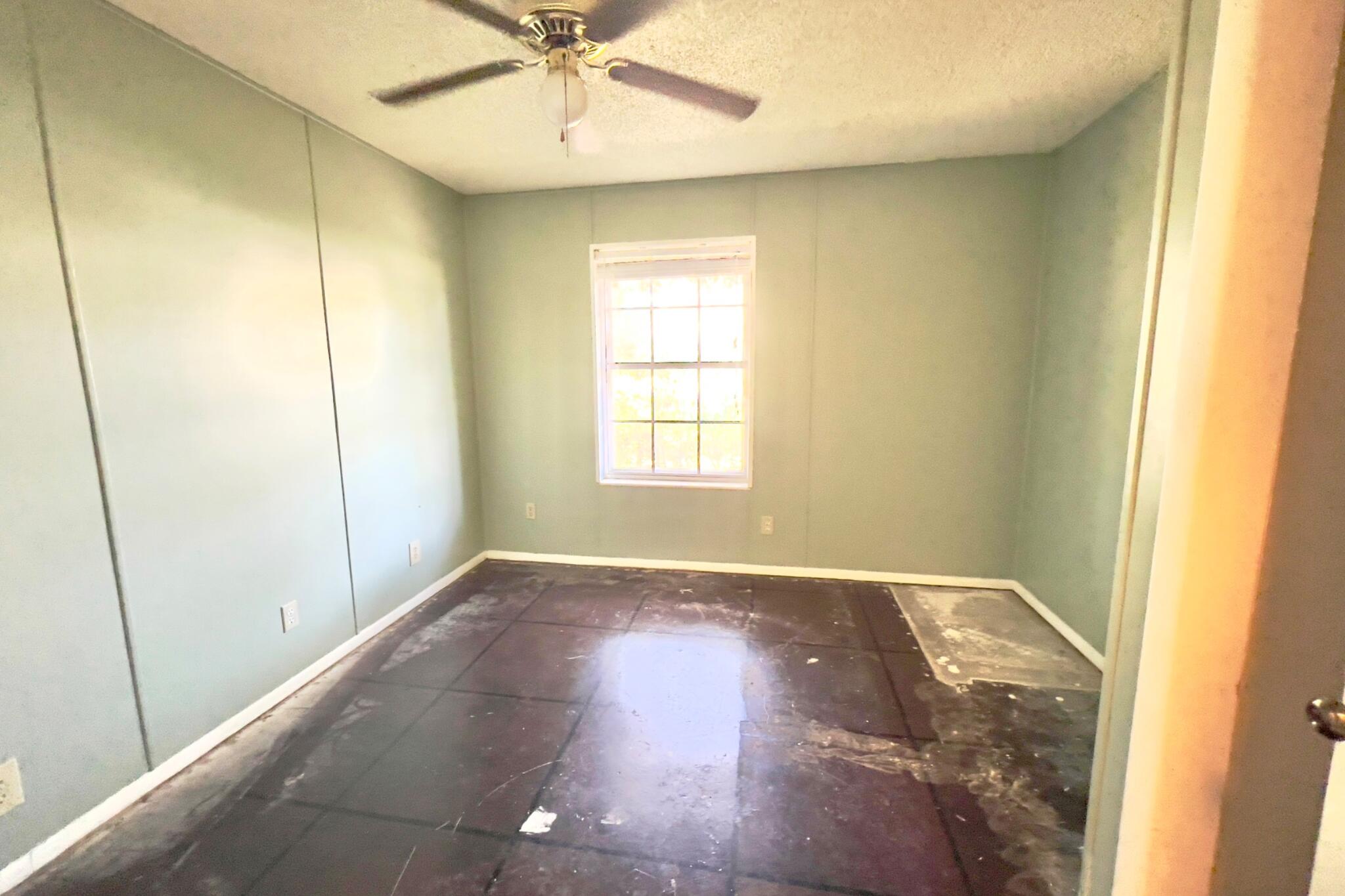 406 Spring Lane Destin, FL 32541 - Photo 24 of 25 an empty room with wooden floor fan and windows