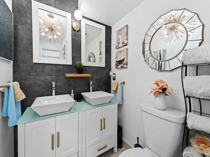 a bathroom with a sink mirror and a toilet