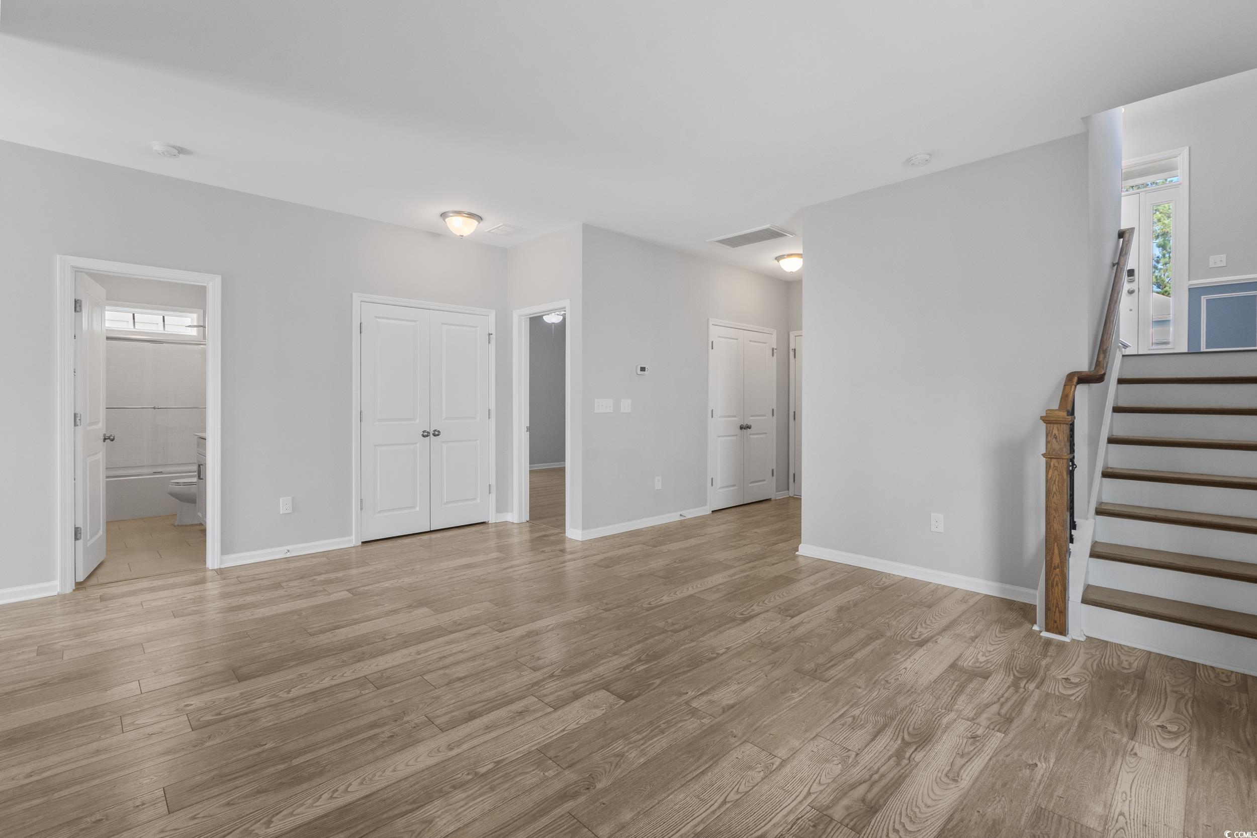 294 Splendor Circle Murrells Inlet, SC 29576 - Photo 25 of 40 Unfurnished living room with stairway, plenty of natural light, and light wood-style floors