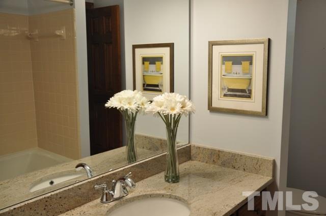 708 Sandown Place Raleigh, NC 27615 - Photo 13 of 25 a bathroom with a granite countertop sink and a mirror