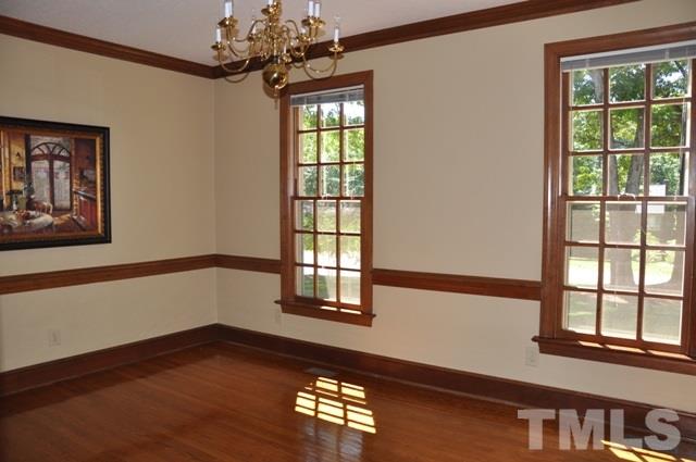 708 Sandown Place Raleigh, NC 27615 - Photo 6 of 25 a view of an empty room with wooden floor and a window