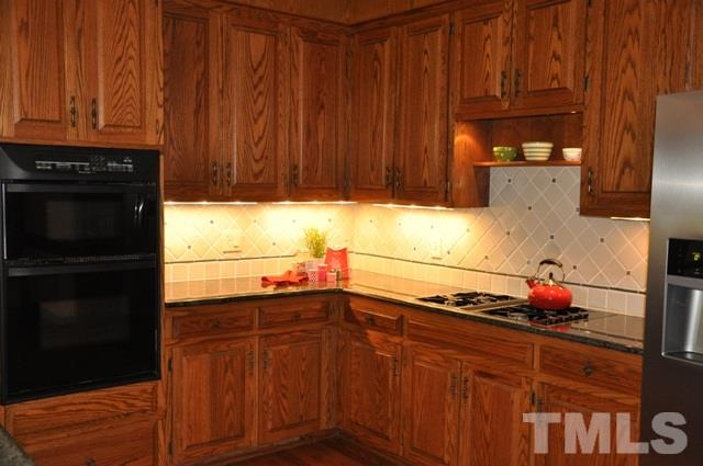 708 Sandown Place Raleigh, NC 27615 - Photo 7 of 25 a kitchen with granite countertop wooden cabinets and a sink