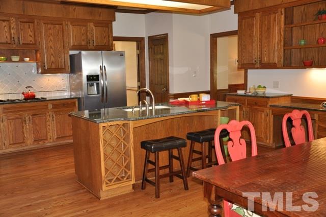 708 Sandown Place Raleigh, NC 27615 - Photo 9 of 25 a kitchen with stainless steel appliances granite countertop a kitchen island a table and chairs