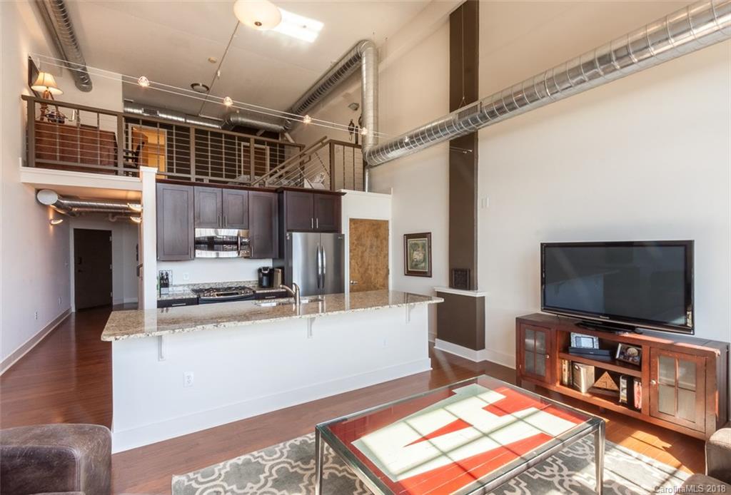 715 North Graham Street, Unit 604 Charlotte, NC 28202 - Photo 6 of 21 a living room with stainless steel appliances furniture and a flat screen tv