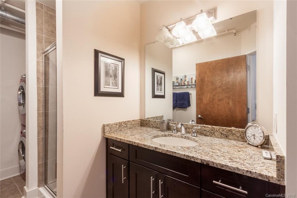 715 North Graham Street, Unit 604 Charlotte, NC 28202 - Photo 8 of 21 a bathroom with a granite countertop sink and a mirror