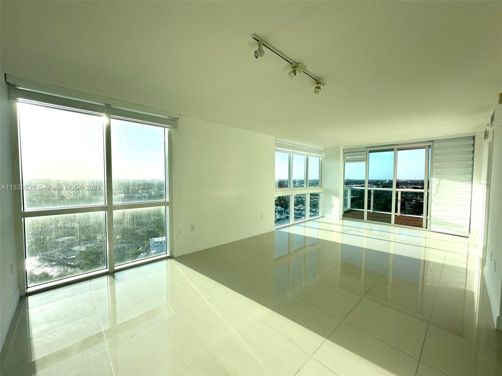 a view of an empty room with a floor to ceiling window and an outdoor view