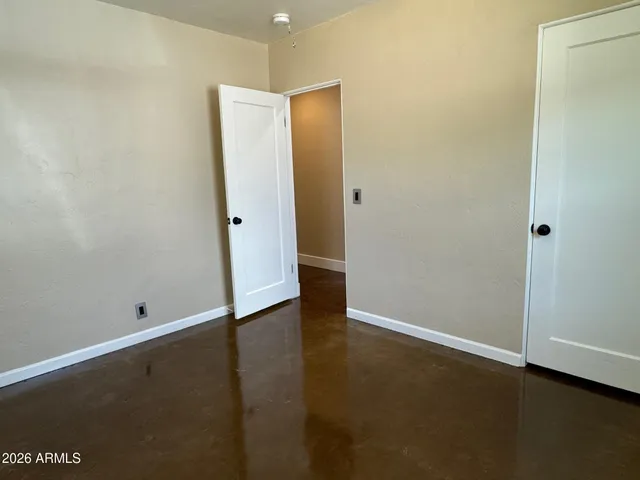 an empty room with wooden floor and a window
