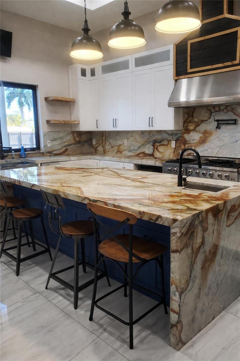 960 Rutherford Lane West Palm Beach, FL 33415 - Photo 3 of 5 a kitchen with stainless steel appliances granite countertop table chairs sink and stove