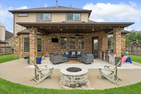 a view of a patio with table and chairs potted plants and large tree