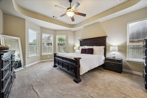 a spacious bathroom with a granite countertop double vanity sink a mirror and a bathtub