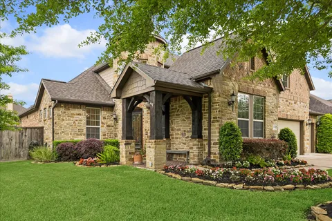 a front view of a house with a garden and plants
