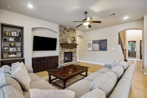 a living room with furniture a flat screen tv and a fireplace