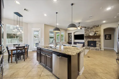 a large kitchen with stainless steel appliances granite countertop a stove microwave and refrigerator