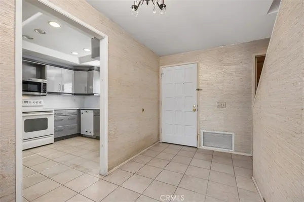 a view of a kitchen with white cabinets and stainless steel appliances