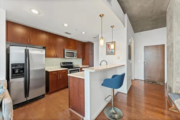 a kitchen with stainless steel appliances granite countertop a refrigerator a stove and a sink