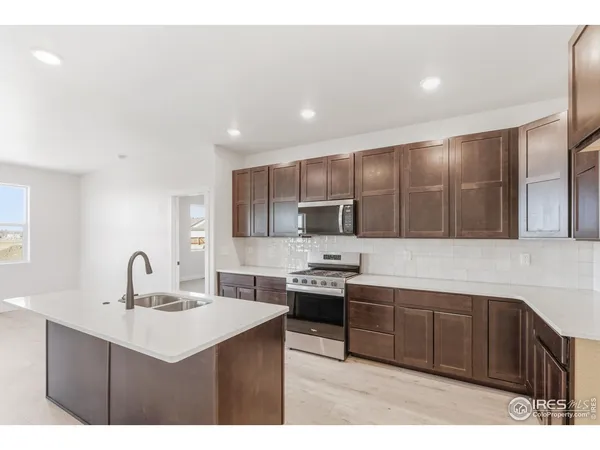 a kitchen with stainless steel appliances a sink a stove and a microwave