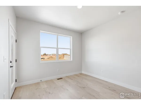 a view of a room with kitchen island stainless steel appliances wooden floor and window