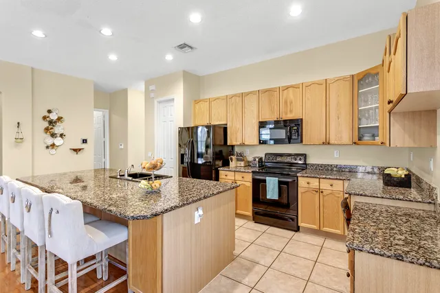 a kitchen with granite countertop stainless steel appliances a stove sink and microwave
