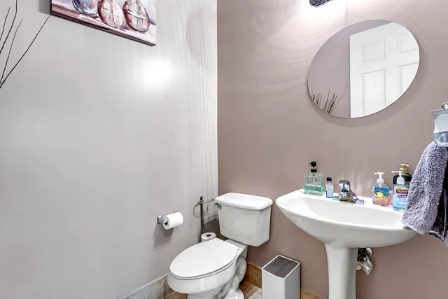 a bathroom with a toilet a sink and mirror
