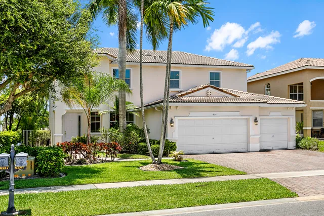 a front view of a house with a garden and plants