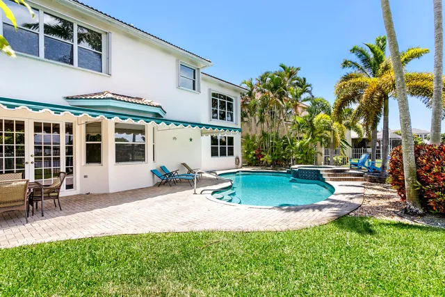 a view of a house with backyard and sitting area