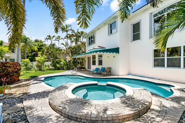 a view of a house with swimming pool and sitting area