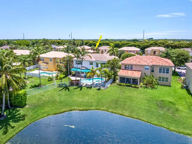 an aerial view of a house with a garden and lake view