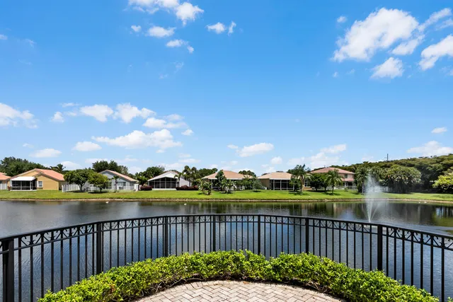 a view of a patio with table and chairs potted plants and floor to ceiling window and wooden fence