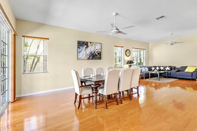 a view of a dining room with furniture a chandelier and wooden floor