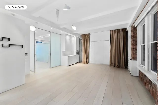 a view of an empty room with window and cabinet