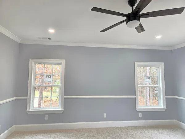 an empty room with windows and fan