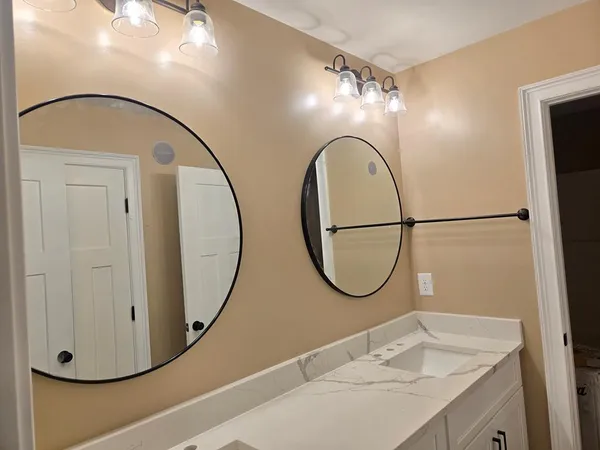 a bathroom with a mirror a vanity and a sink