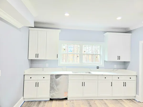 a kitchen with granite countertop white cabinets and white appliances