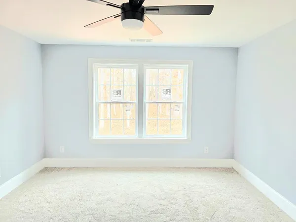 an empty room with a window and a ceiling fan