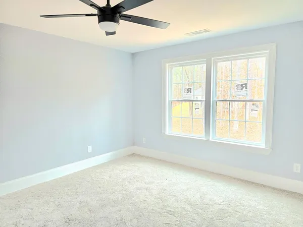 an empty room with a window and a fan