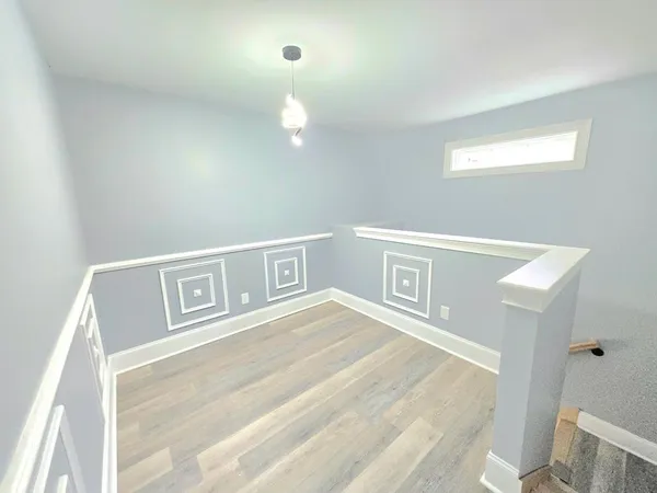 a view of a bedroom with wooden floor