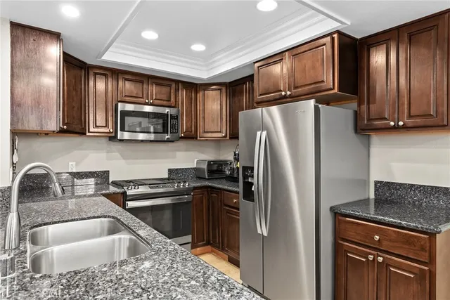 a open kitchen with granite countertop a sink and dishwasher with wooden floor