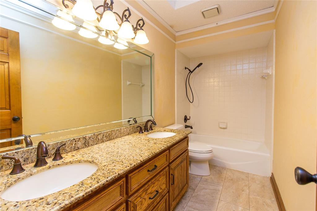 3014 Pecan Ridge Drive Rowlett, TX 75088 - Photo 15 of 29 a bathroom with a granite countertop sink a toilet a mirror and shower